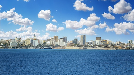 View of the Senegal capital of Dakar, Africa. It is a city panorama taken from a boat. There are large modern buildings and a blue sky with clouds @ credit Depositphotos