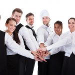 Waiters and waitresses stacking hands
