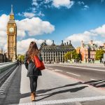 London city urban lifestyle tourist woman walking. Businesswoman commuting going to work on Westminster bridge street early morning. Europe travel destination, England, Great Britain, UK.