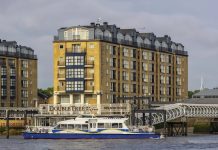 Ouverture novembre 2025, UK | a&o Hostels acquiert son premier hôtel à Londres avec la reprise de l’ancien DoubleTree by Hilton Docklands Riverside LONDON, UK - JULY 04, 2018: Thames Clipper river bus in front of DoubleTree by Hilton Hotel on Docklands Riverside @ credit Depositphotos.com