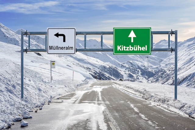 Austria ski town Mullneralm and Kitzbuhel road big sign with a lot of snow and mountain sky @ credit Depositphotos.com