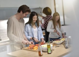 Flatmates cooking together at home @ credit Depositphotos.com